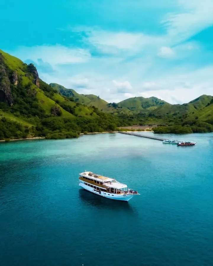 Phinisi anchored in a turquoise bay off Manjarite Island